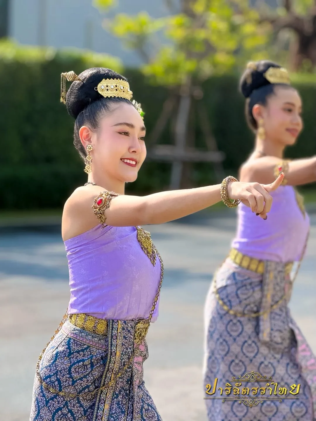 นางรำ 2 คน ชุดสไบม่วง ฝึกท่ารำกลางแจ้ง